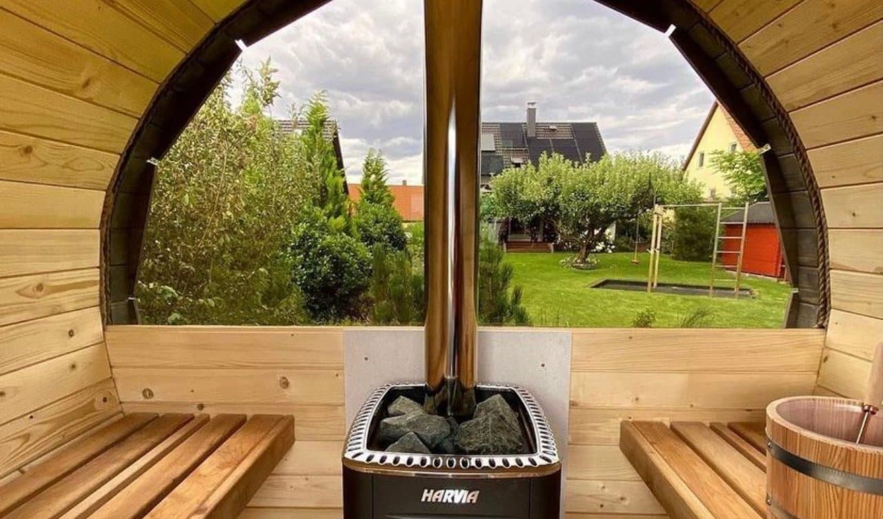 sauna z okrągłym oknem widok ze środka na ogród